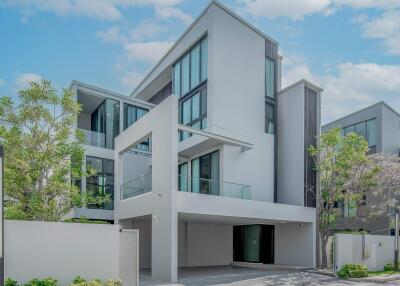 Modern multi-story residential building with large windows and balcony