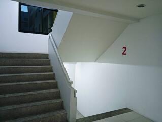 Staircase with white walls and a window