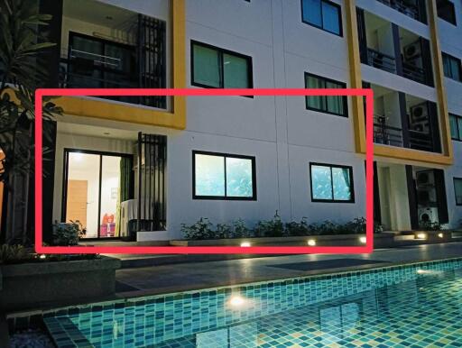 Night view of apartment building with illuminated swimming pool