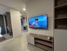 Modern living room with wall-mounted TV and open view to kitchen