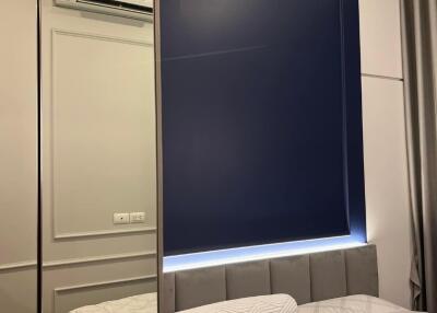 Modern bedroom with mirrored wardrobe and blue accent wall