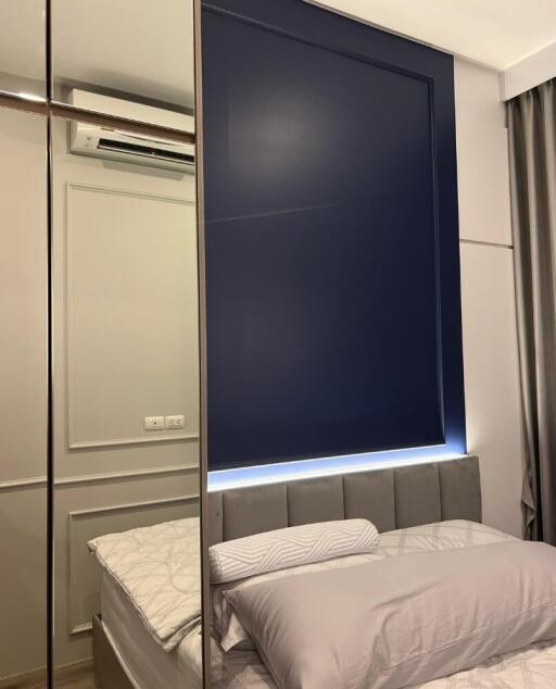 Modern bedroom with mirrored wardrobe and blue accent wall