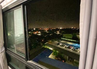 Nighttime view from the window showing the parking area and distant city lights