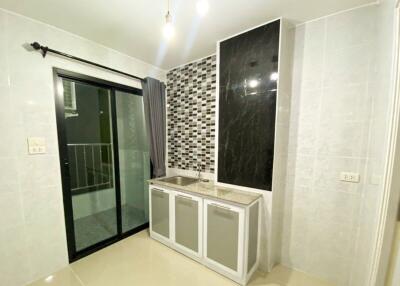 Modern kitchen area with tiled backsplash and sliding glass door