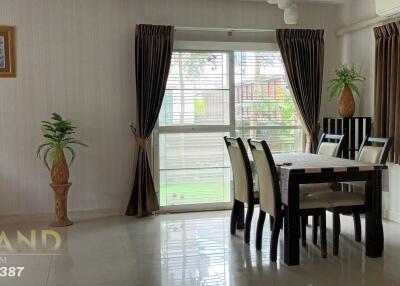 Dining area with table and chairs, window with curtains