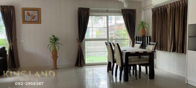 Dining area with table and chairs, window with curtains