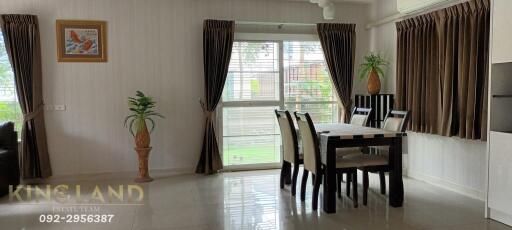 Dining area with table and chairs, window with curtains