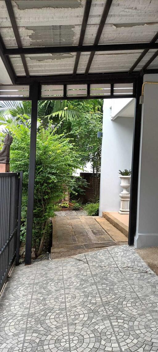 Outdoor entryway with tiled pathway and greenery