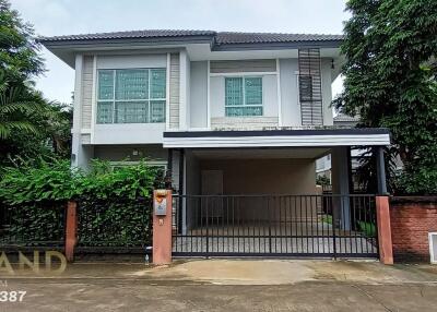 Exterior view of a two-story house with a gated driveway.