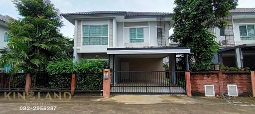 Exterior view of a two-story house with a gated driveway.