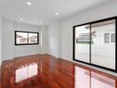 Spacious living room with wooden floors and large windows