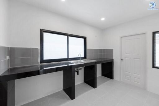 Modern kitchen with black countertops and tiled backsplash