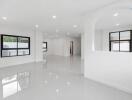 Spacious white-walled main living area with large windows