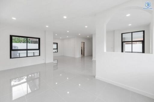 Spacious white-walled main living area with large windows