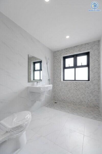 Spacious and modern bathroom with a large window, sink, mirror, and toilet.