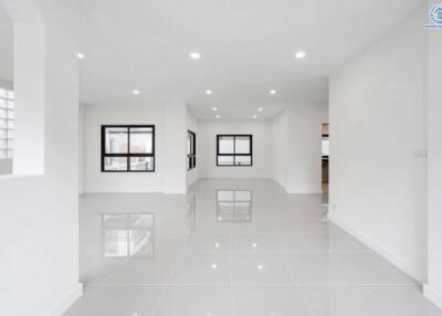 Spacious and well-lit living room with modern white interior and large windows