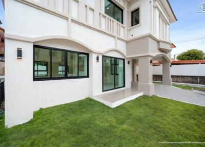 Exterior view of a modern residential building showing lawn and large windows.