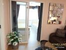 Cozy living room with sofa and decorative mirror, adjacent to a bedroom behind glass sliding doors