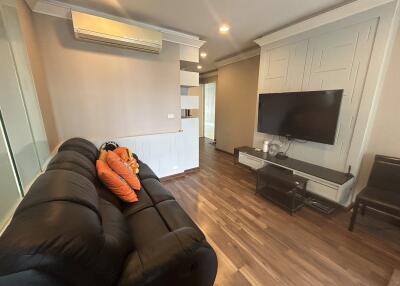 Modern living room with hardwood floors and a mounted TV