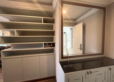 Living area with built-in shelves and a large mirror