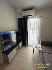 Modern living room with a sofa, TV, air conditioner, and a coffee table