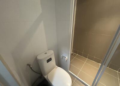 A clean and modern bathroom featuring a toilet and a shower area