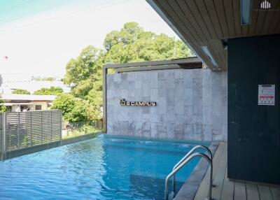 Outdoor swimming pool with stair access and surrounding greenery