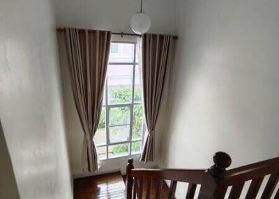 View of an indoor staircase with a window and curtains