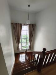 View of an indoor staircase with a window and curtains