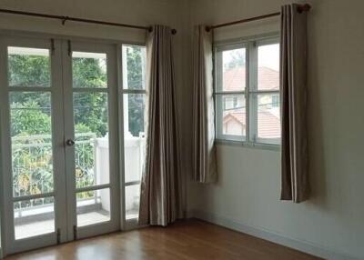 Bright bedroom with large windows and a door to the balcony