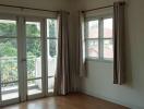 Bright bedroom with large windows and a door to the balcony