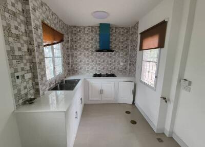 Modern kitchen with tiled backsplash and white cabinets