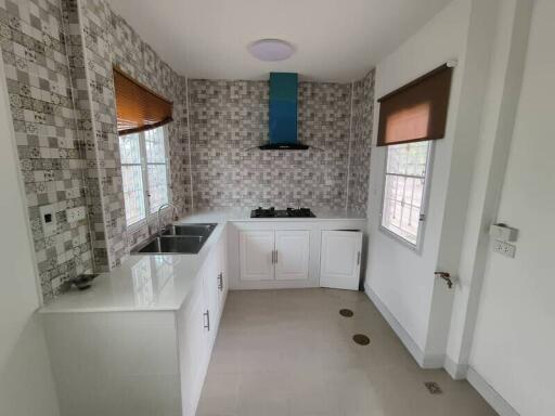 Modern kitchen with tiled backsplash and white cabinets