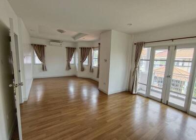 Spacious living room with wooden flooring and large windows