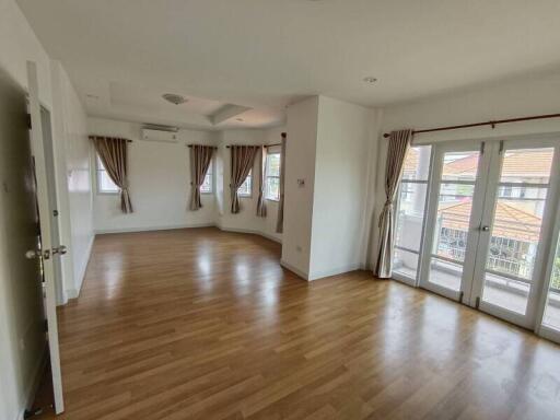 Spacious living room with wooden flooring and large windows