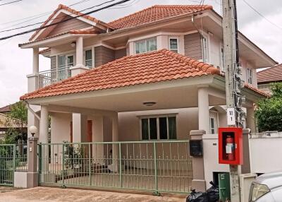 two-story house with a tiled roof and a covered carport