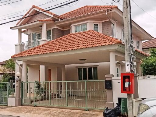 two-story house with a tiled roof and a covered carport