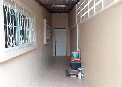 Narrow hallway with storage items and a door at the end