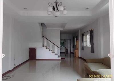 Spacious living room with modern lighting and staircase