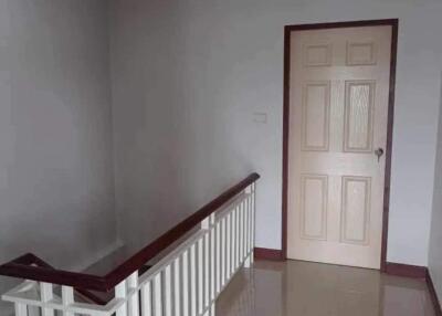 Hallway with railing and wooden door