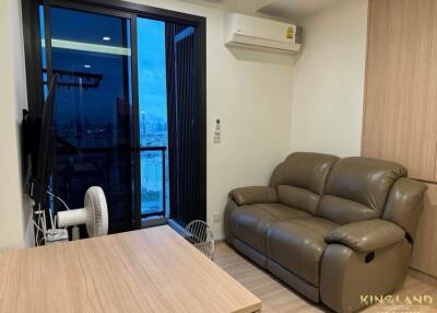 Cozy living room with a sofa and a view of the city through the balcony window