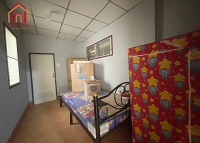 Bedroom with simple furnishing and cardboard boxes