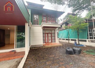 Exterior view of a two-story house with a paved front yard