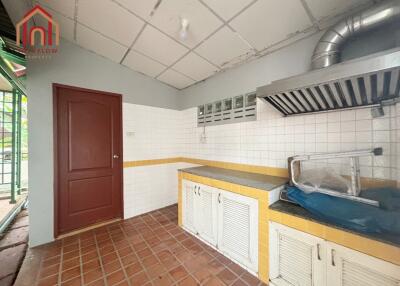 Simple and functional kitchen with red door and tiled flooring