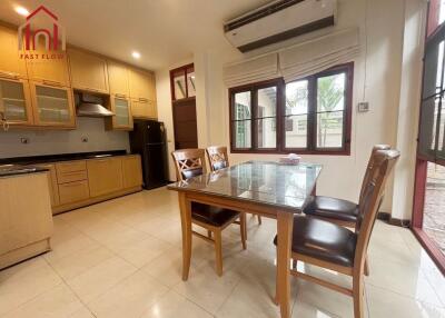 Dining and kitchen area with wooden cabinets and glass table