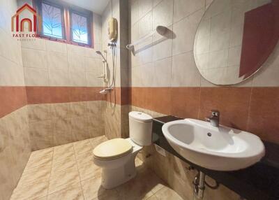 Spacious bathroom with modern amenities and tiled walls