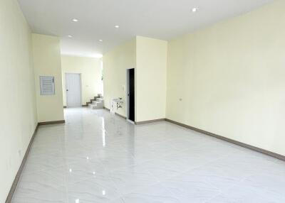 Spacious main living area with tiled floors and stairs leading to upper level