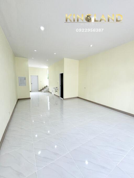 Spacious main living area with tiled floors and stairs leading to upper level