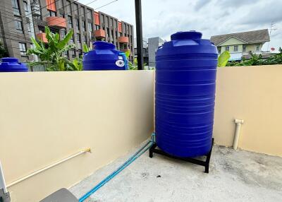 Outdoor area with water tank and utility connections