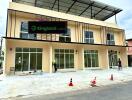 Exterior view of building under construction with large glass windows and a sign reading 'Kingland Condo'